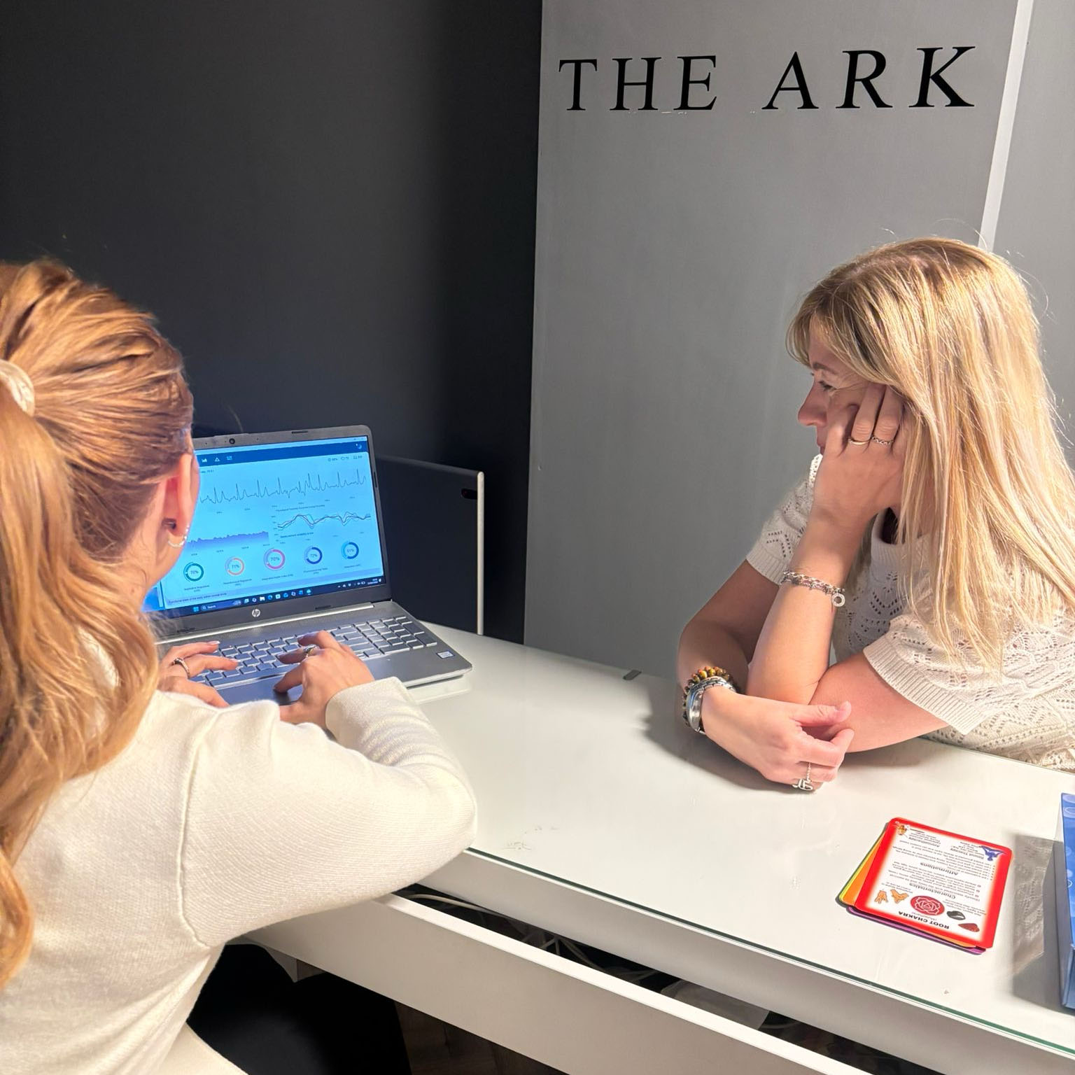 Ark practitioner reviewing biometric results with a client on a laptop at The Ark